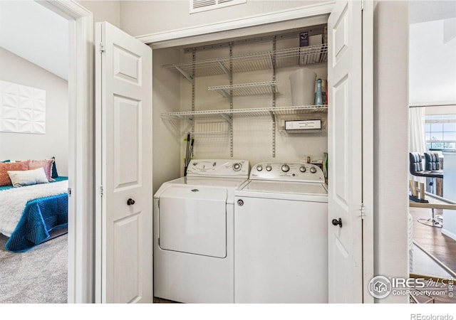 laundry room featuring washer and clothes dryer and light carpet