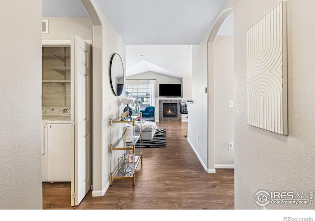 hallway featuring lofted ceiling and dark hardwood / wood-style floors