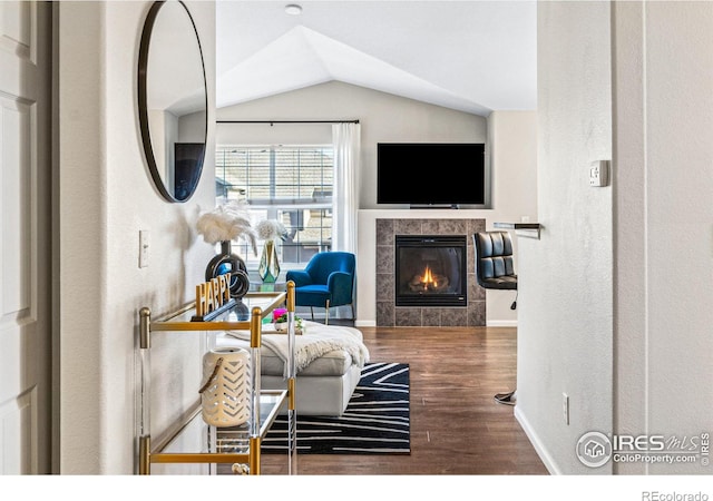 living room featuring lofted ceiling, hardwood / wood-style floors, and a fireplace