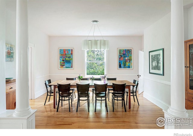 dining area featuring decorative columns and light wood-type flooring