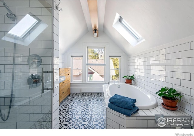 bathroom with tiled tub, tile patterned floors, and lofted ceiling