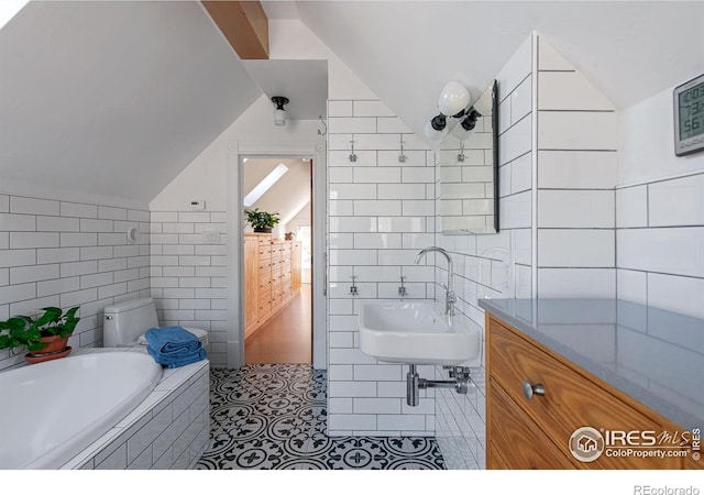 bathroom featuring sink, tile walls, tile patterned floors, and vaulted ceiling