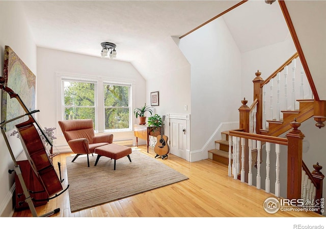 living area with light wood-type flooring and lofted ceiling