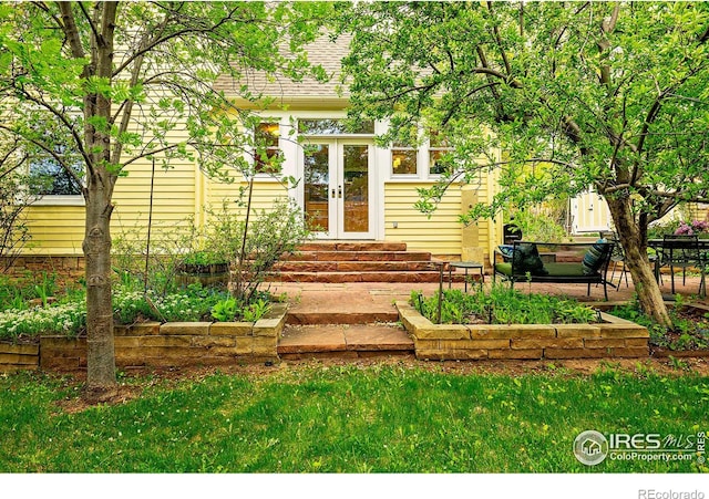 property entrance with french doors and a lawn