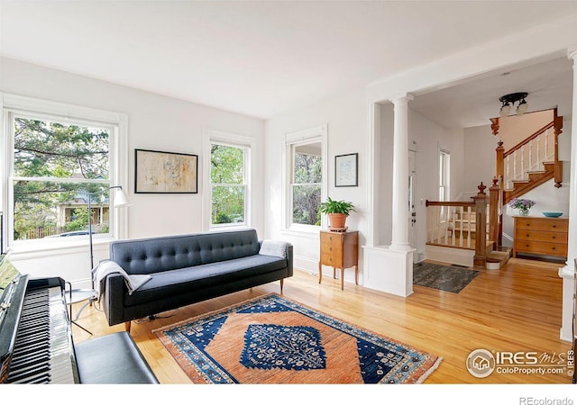 living room with hardwood / wood-style flooring and ornate columns