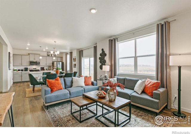 living room featuring a chandelier and light hardwood / wood-style flooring