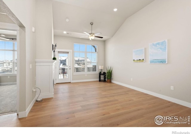 unfurnished living room with lofted ceiling, light hardwood / wood-style floors, and ceiling fan