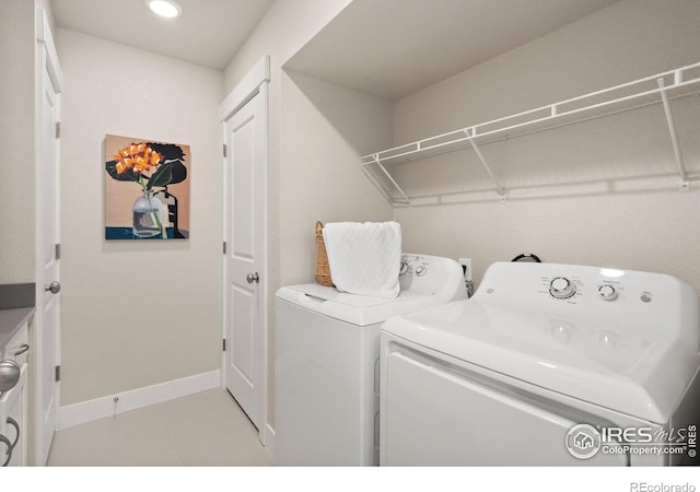 laundry area with separate washer and dryer and light tile patterned floors