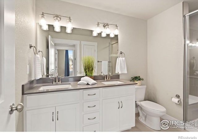 bathroom featuring vanity, an enclosed shower, and toilet