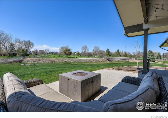 view of patio / terrace with an outdoor living space with a fire pit and a rural view