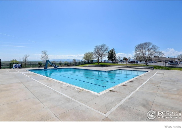 view of swimming pool featuring a water slide and a patio area