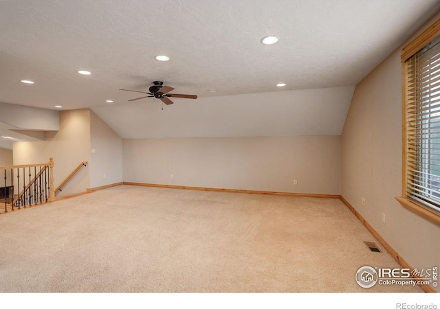 bonus room featuring ceiling fan, light colored carpet, and lofted ceiling