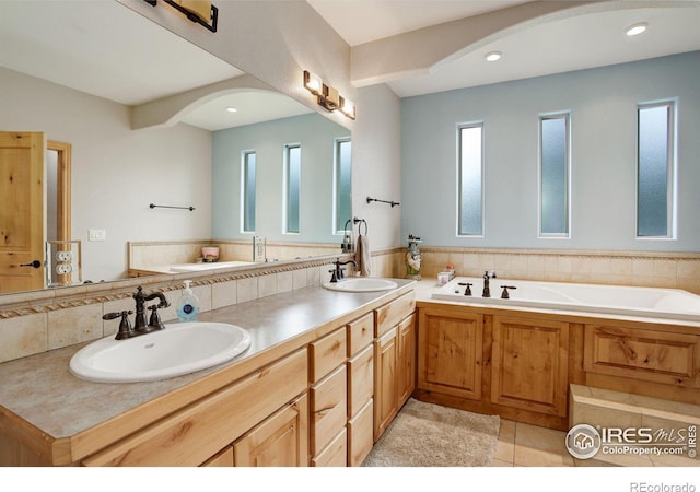 bathroom featuring backsplash, plenty of natural light, a bathing tub, and vanity