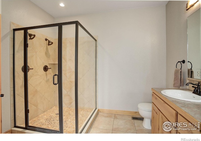 bathroom featuring vanity, toilet, a shower with shower door, and tile patterned flooring