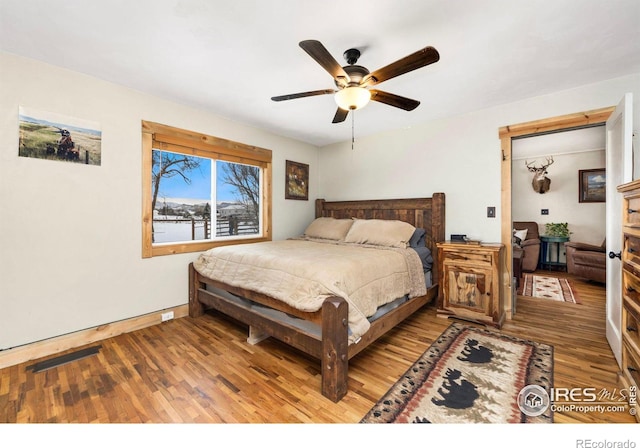 bedroom with ceiling fan and hardwood / wood-style flooring