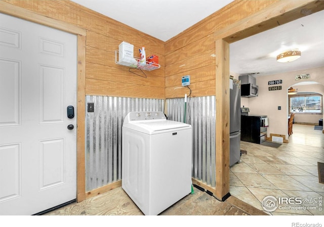 washroom with washer / dryer, wooden walls, and light tile patterned floors