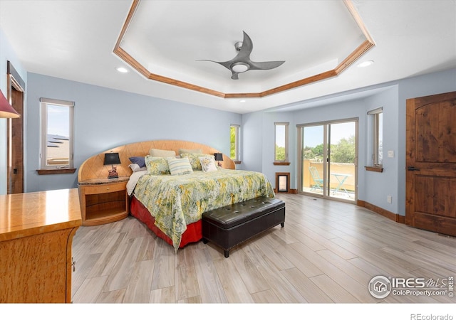 bedroom featuring access to exterior, ceiling fan, light hardwood / wood-style flooring, and a tray ceiling