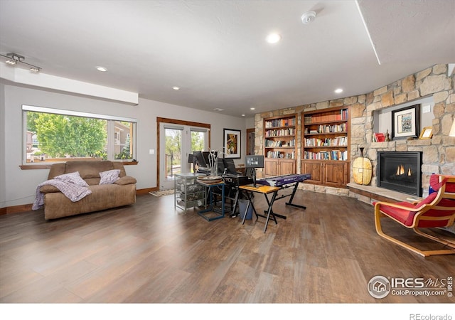 dining area featuring hardwood / wood-style floors and a stone fireplace