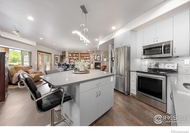 kitchen with pendant lighting, white cabinetry, and stainless steel appliances