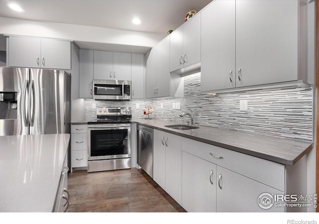 kitchen with sink, stainless steel appliances, white cabinets, and backsplash