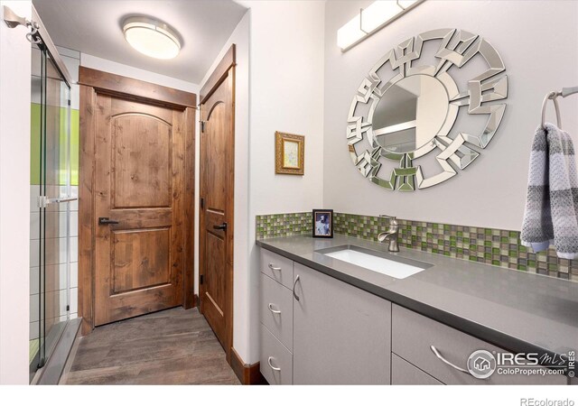 bathroom with vanity, backsplash, and hardwood / wood-style floors