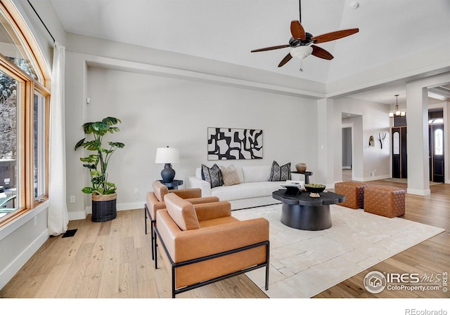 living room with ceiling fan, vaulted ceiling, and light wood-type flooring