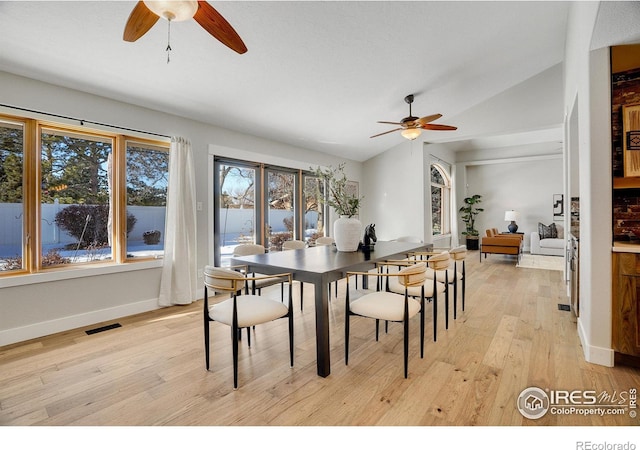 dining space with ceiling fan, light hardwood / wood-style floors, and lofted ceiling