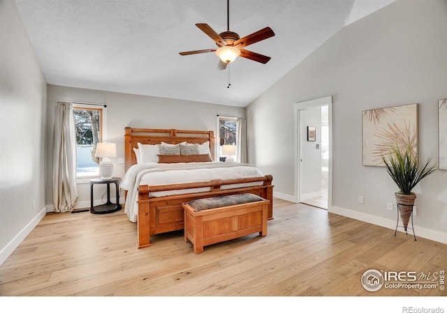 bedroom with vaulted ceiling, ceiling fan, ensuite bathroom, a textured ceiling, and light hardwood / wood-style floors