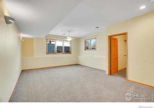 empty room with ceiling fan and light colored carpet