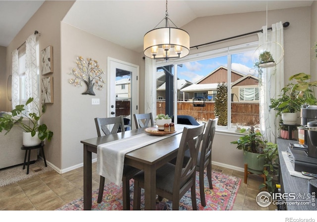 dining area with baseboards, vaulted ceiling, and a notable chandelier