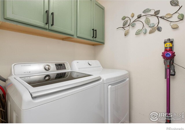 clothes washing area with cabinet space and separate washer and dryer