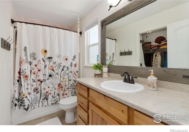 bathroom featuring toilet, tile patterned floors, a shower with shower curtain, and vanity