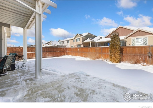 yard covered in snow with a fenced backyard