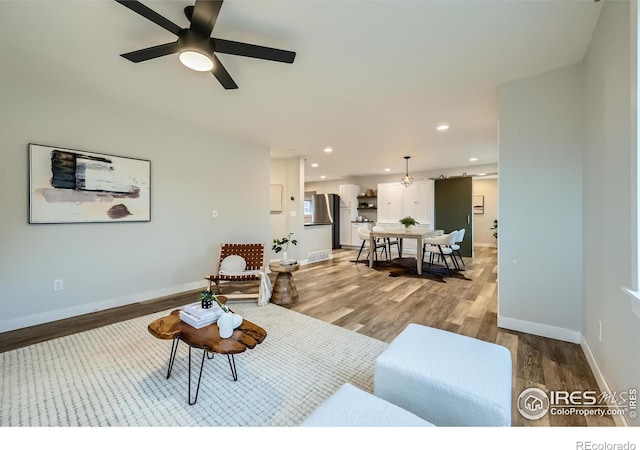 living room with ceiling fan and light hardwood / wood-style floors