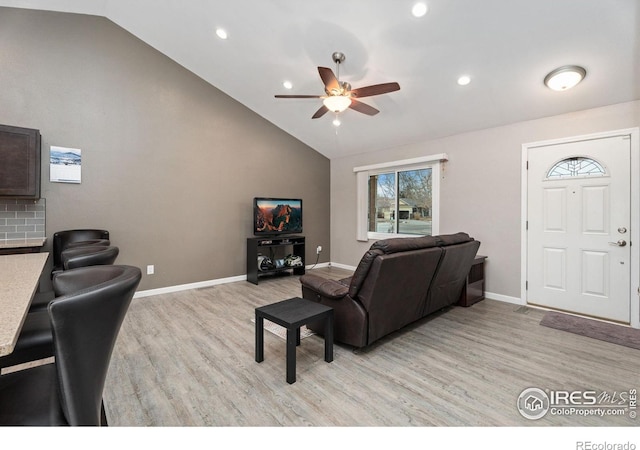 living room with ceiling fan, light hardwood / wood-style floors, and lofted ceiling