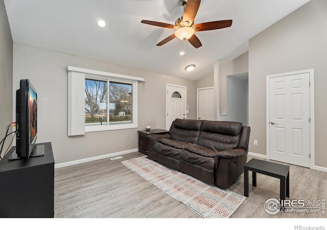 living room with hardwood / wood-style flooring, lofted ceiling, and ceiling fan