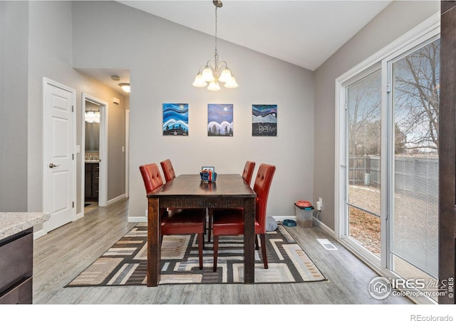 dining space featuring light wood-type flooring, vaulted ceiling, and a wealth of natural light