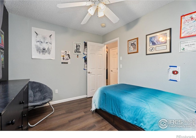 bedroom with ceiling fan, a textured ceiling, and dark hardwood / wood-style flooring