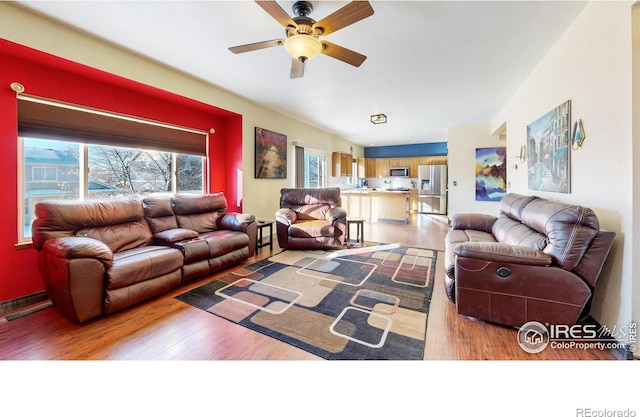 living room featuring ceiling fan and hardwood / wood-style floors