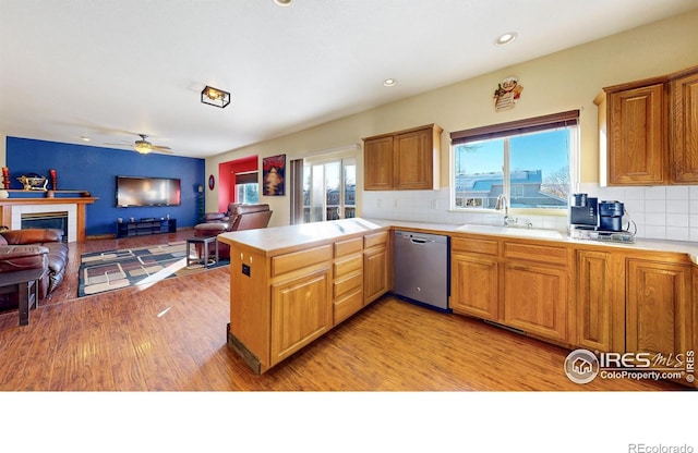 kitchen with decorative backsplash, sink, dishwasher, and kitchen peninsula