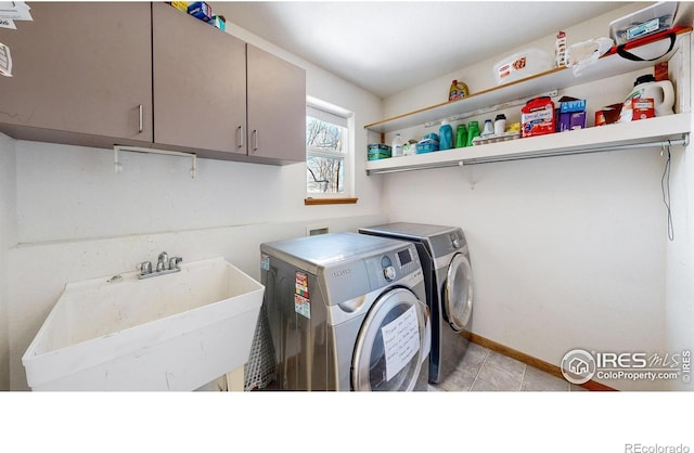 clothes washing area featuring sink, cabinets, and independent washer and dryer