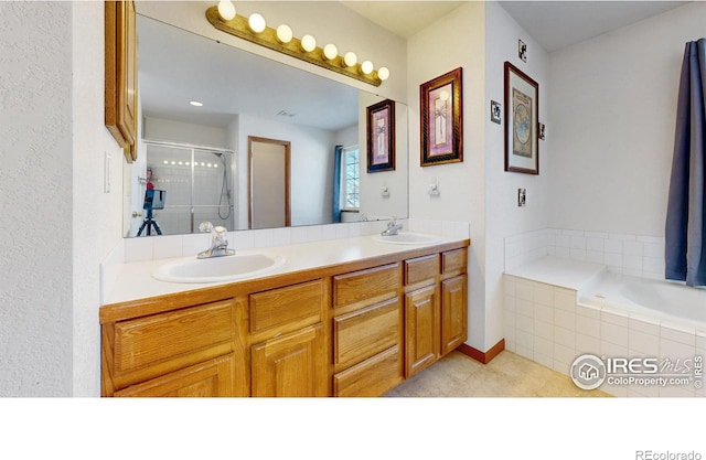 bathroom featuring vanity and independent shower and bath