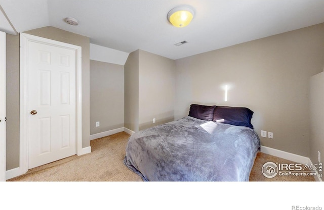 carpeted bedroom with vaulted ceiling