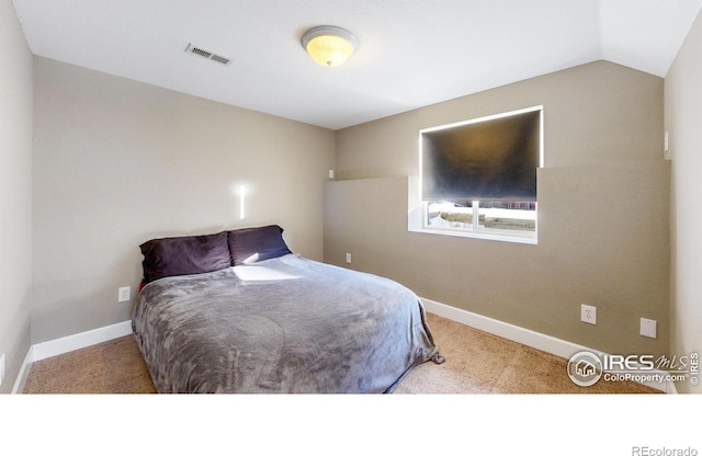 carpeted bedroom with vaulted ceiling