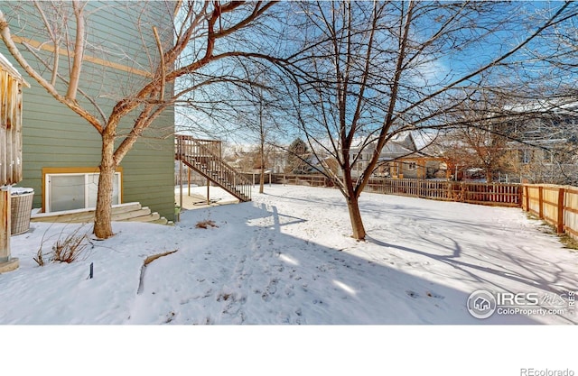 yard layered in snow featuring central AC unit