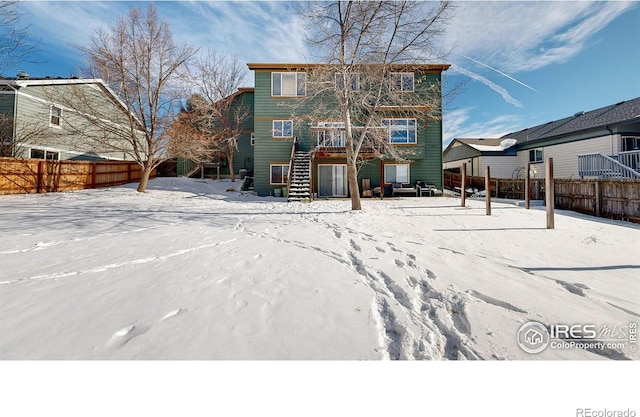 view of snow covered back of property