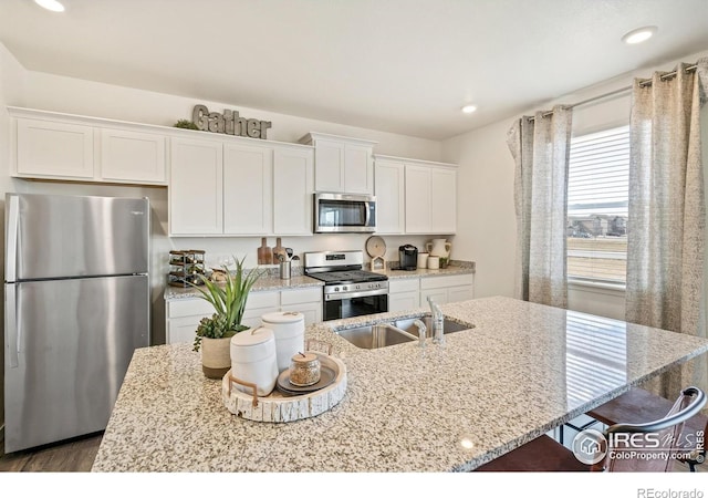 kitchen with white cabinetry, a kitchen island with sink, and appliances with stainless steel finishes