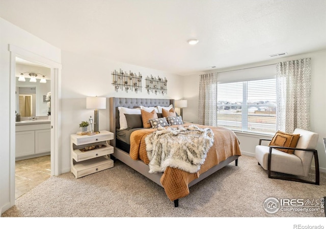 bedroom featuring light colored carpet and ensuite bathroom