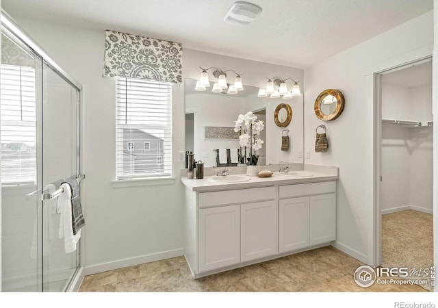 bathroom featuring a shower with door and vanity