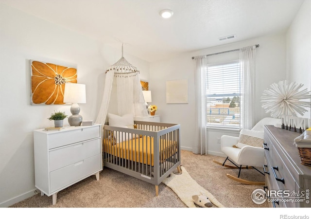 bedroom featuring light carpet and a crib